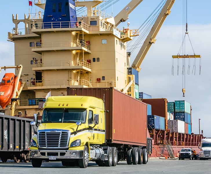 Sunbury truck next to a large ocean vessel